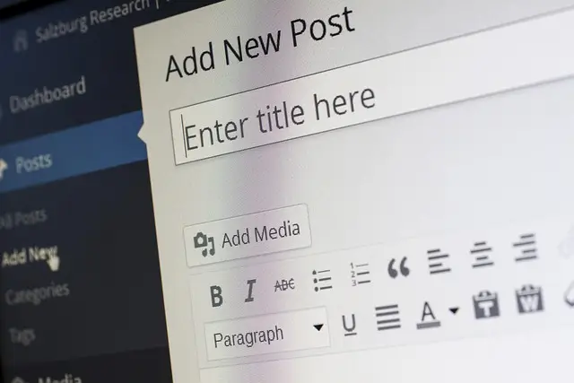 A computer screen displays the WordPress editor with the Add New Post page open, illustrating How to Create a WordPress Blog Post with AVI Lead Gen Builds, featuring title and content fields alongside formatting and media options.